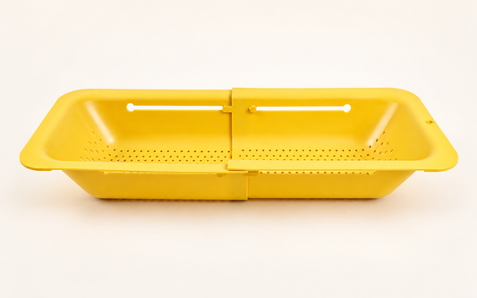 Yellow Blue Ginkgo expandable colander with drainage holes and an adjustable sliding design on a warm white background.