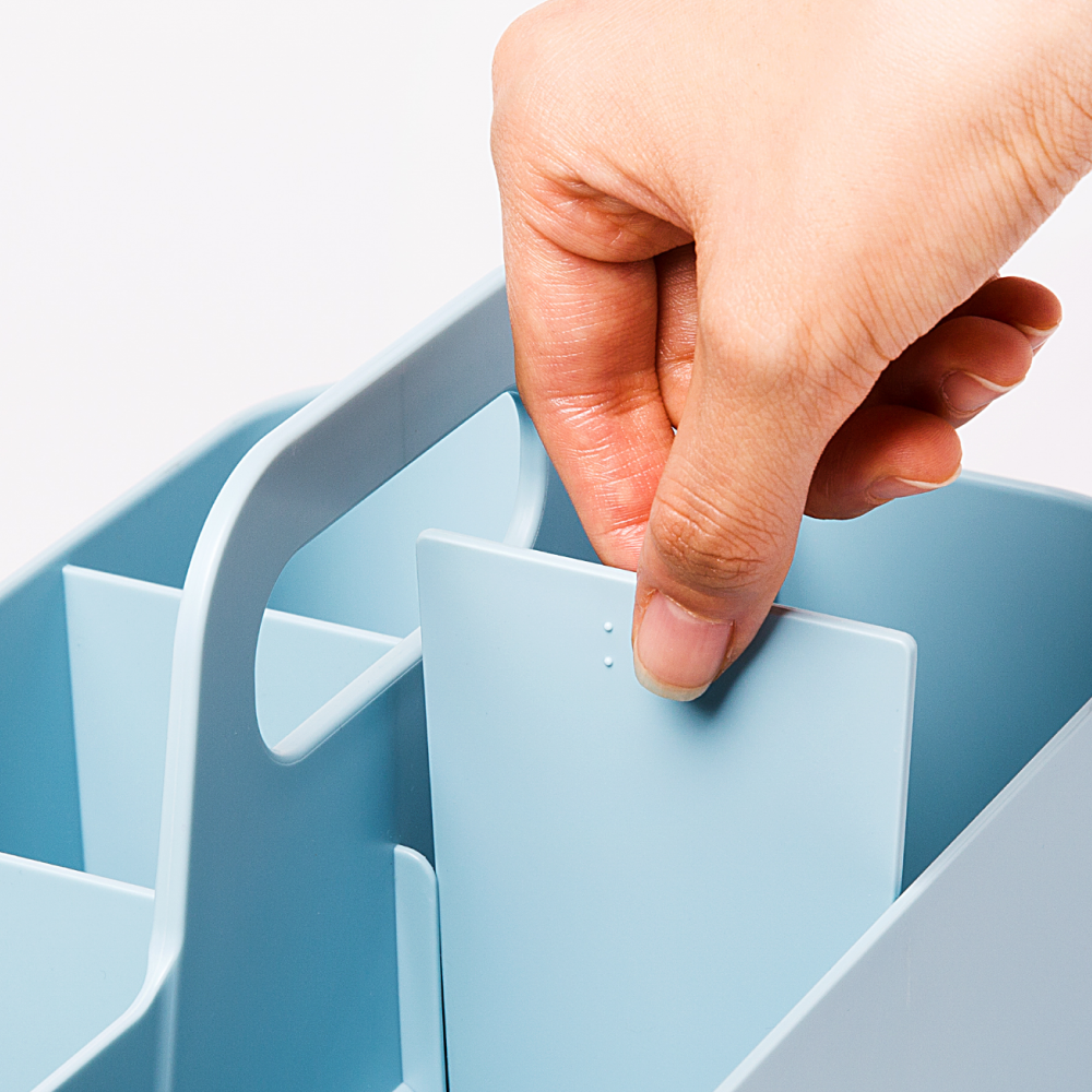 Hand placing a light blue removable divider in a Blue Ginkgo caddy.