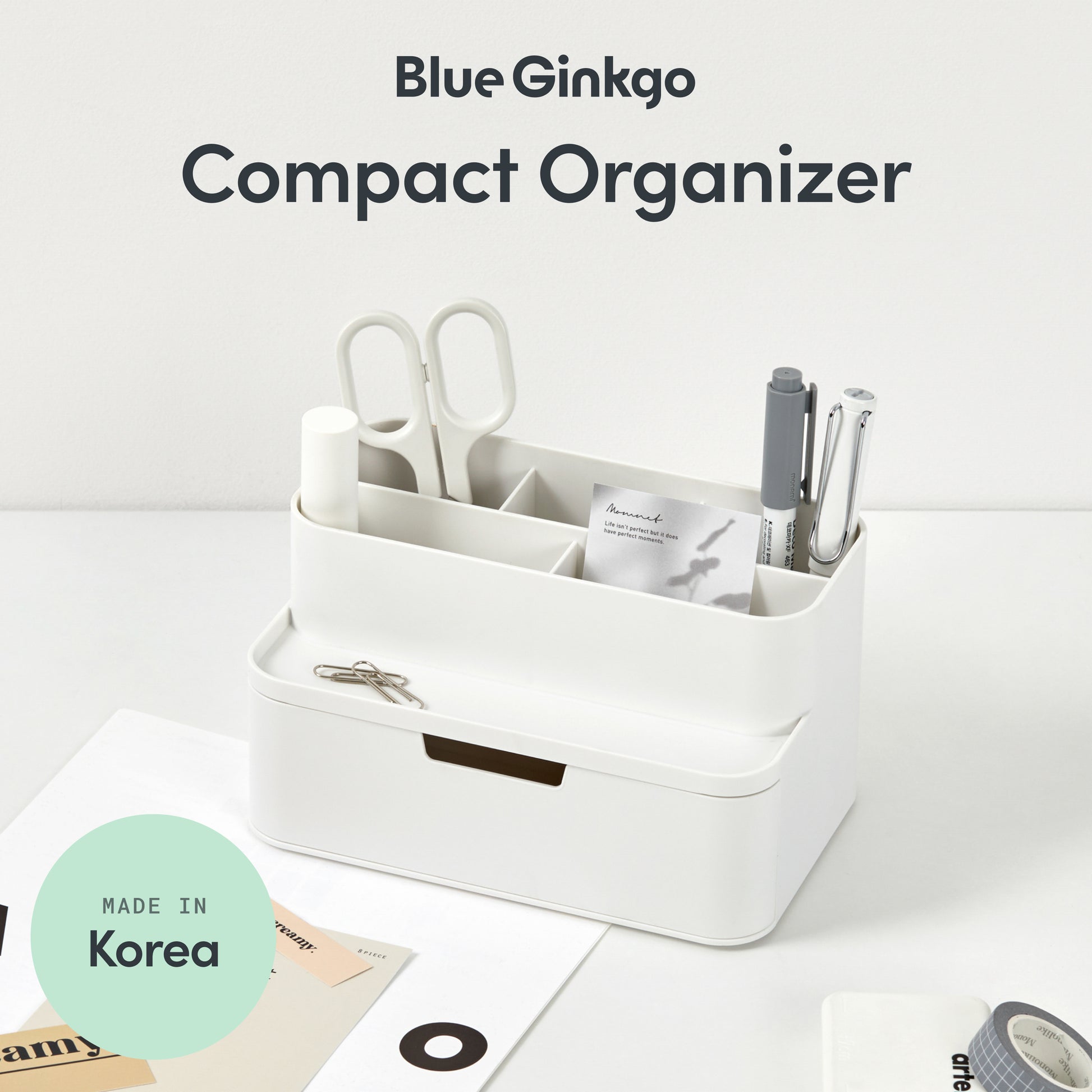 White compact desk organizer with stationery items on a light gray background.