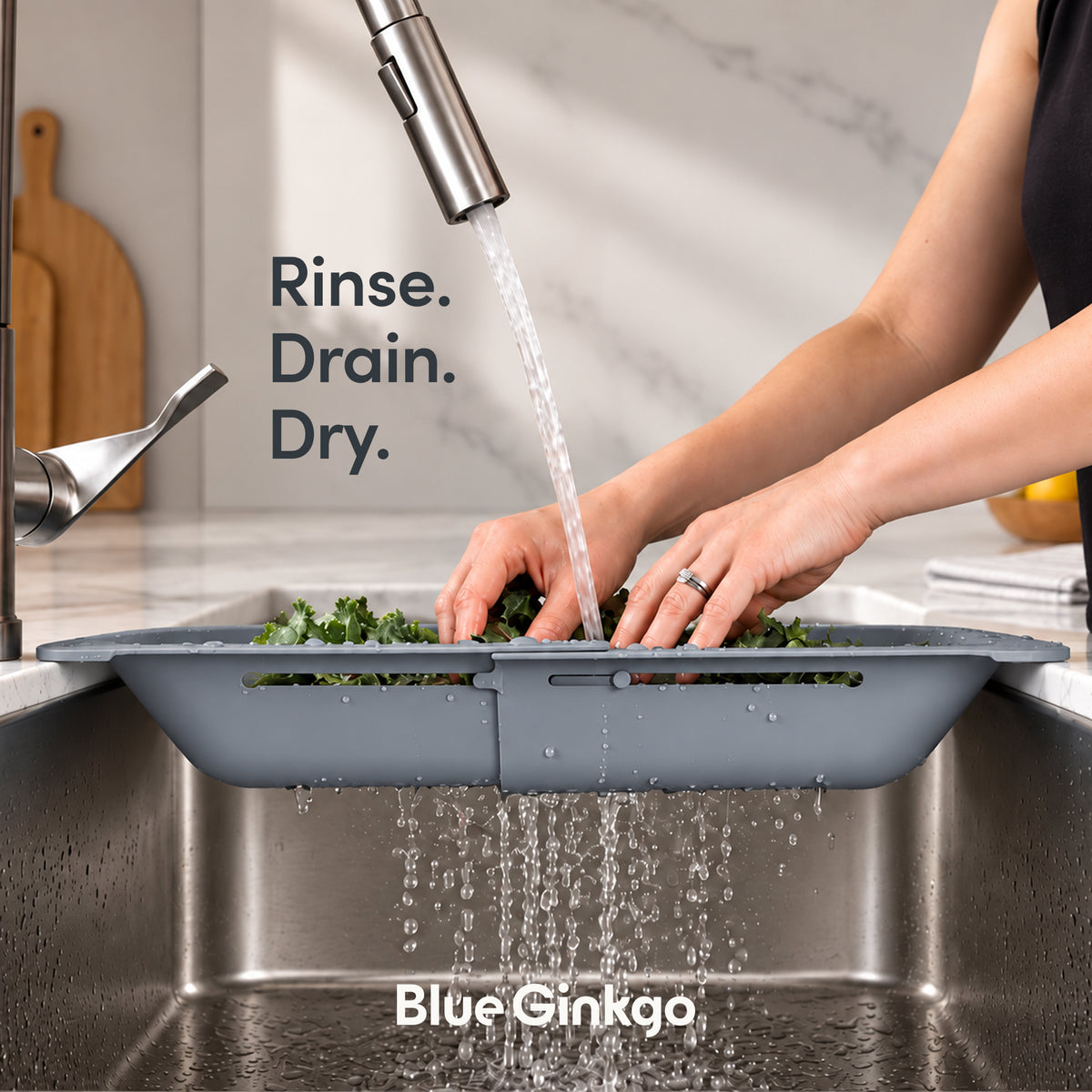 Grey over the sink colander across a sink showing the water draining out the bottom