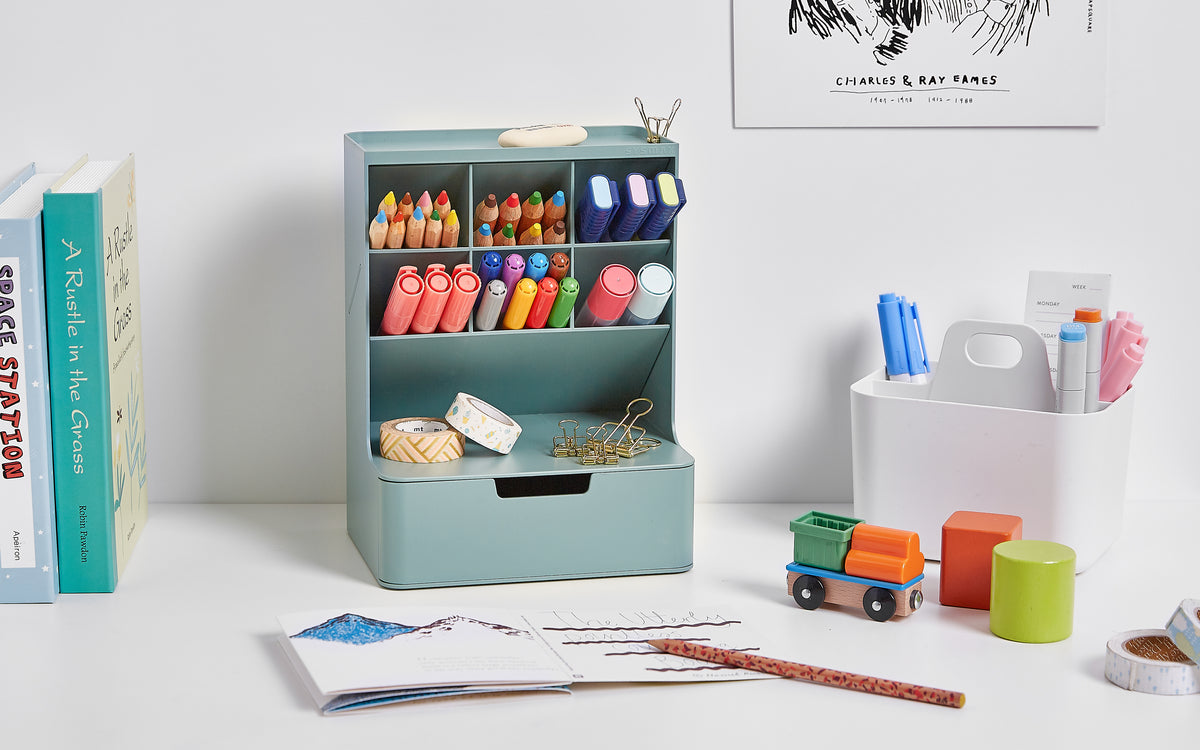 A green colored Blue Ginkgo Hive Desk Organizers storing kids art and writing supplies on a white desk.
