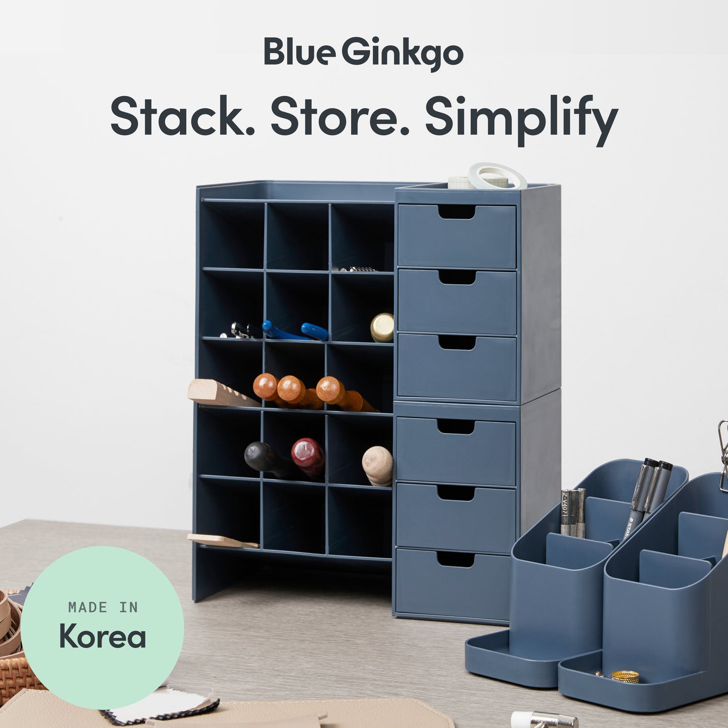 Two dark blue Hive Stack desk organizers with partition on a work top.
