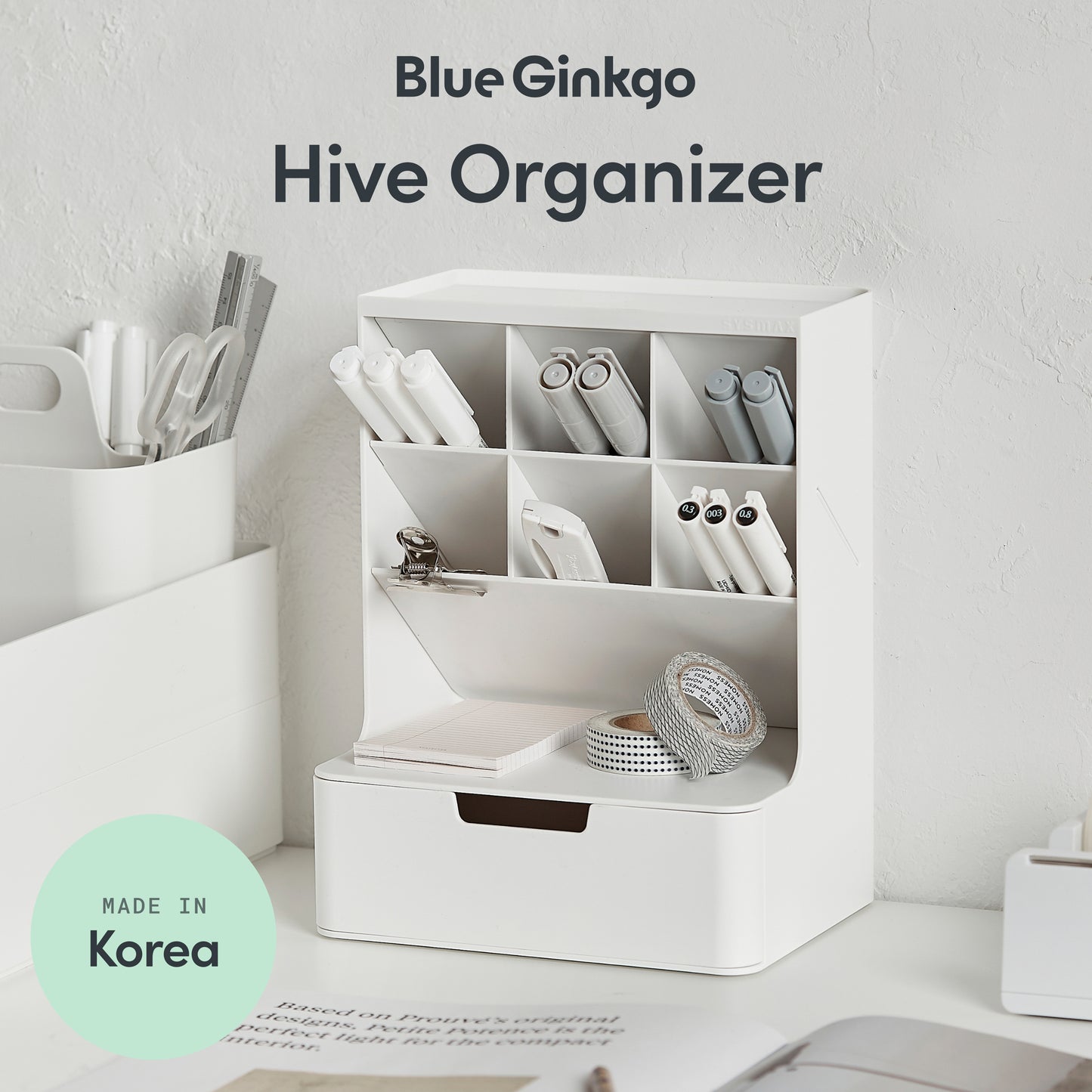 White organizer with compartments on a desk, labeled 'Blue Ginkgo Hive Organizer' with 'Made in Korea' badge.
