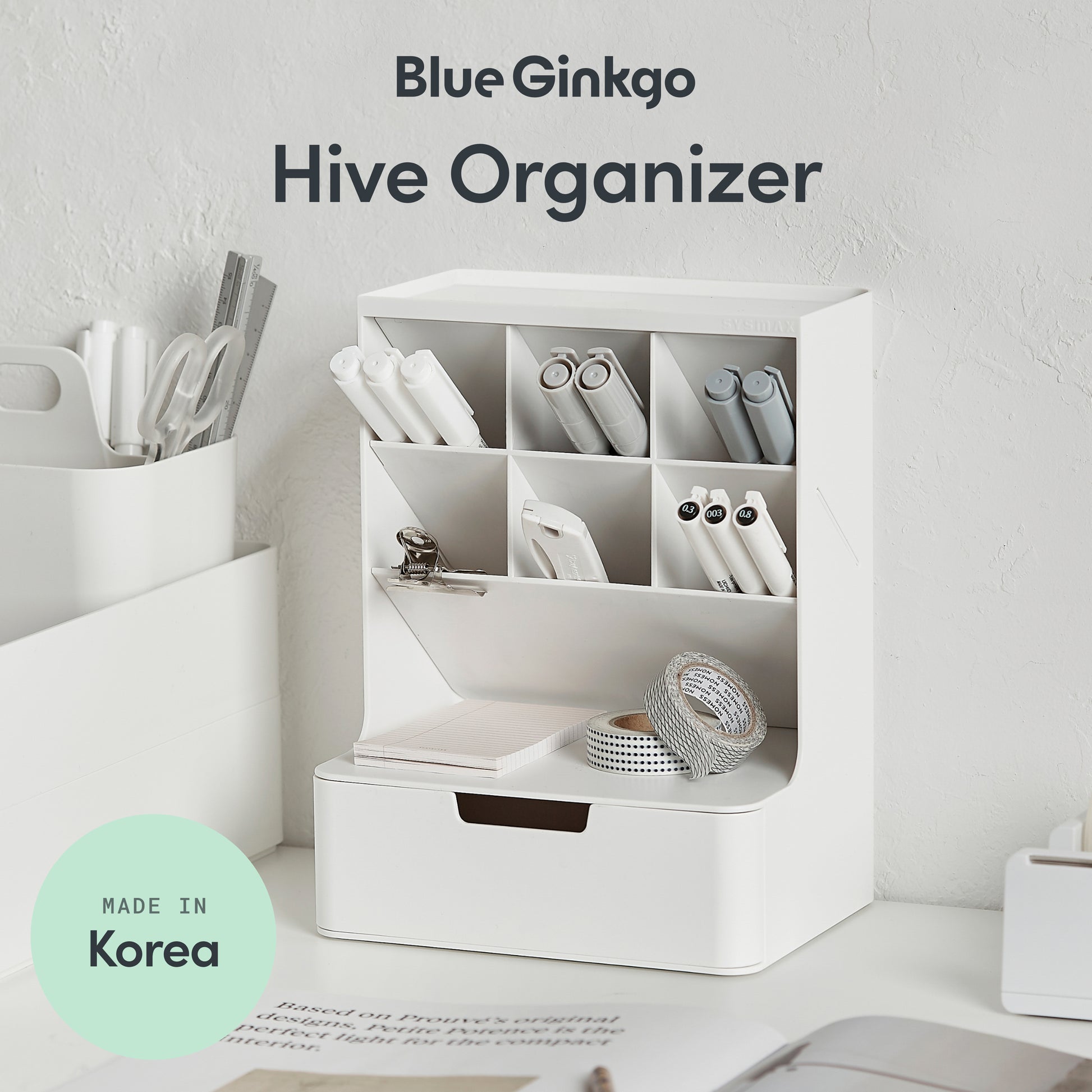 White organizer with compartments on a desk, labeled 'Blue Ginkgo Hive Organizer' with 'Made in Korea' badge.