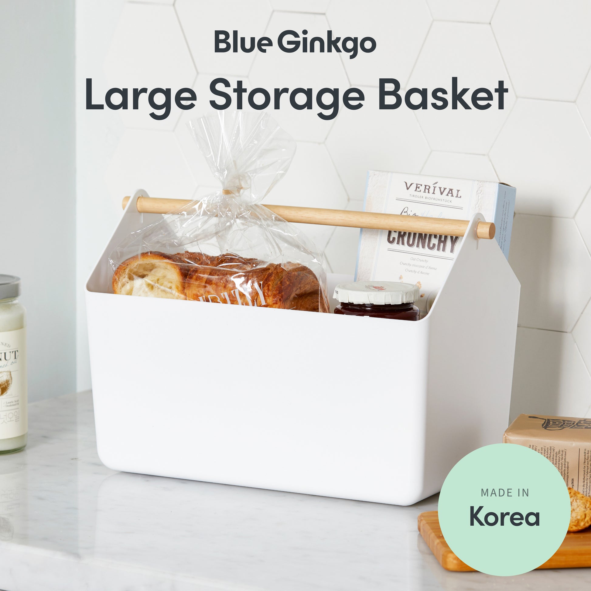 White storage basket with a wooden handle containing bread and snacks.