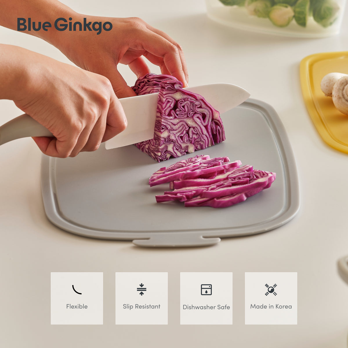 Chopping cabbage on a Blue Ginkgo silicone cutting board, with highlights for flexibility, slip resistance, dishwasher safety, and Korean manufacture.