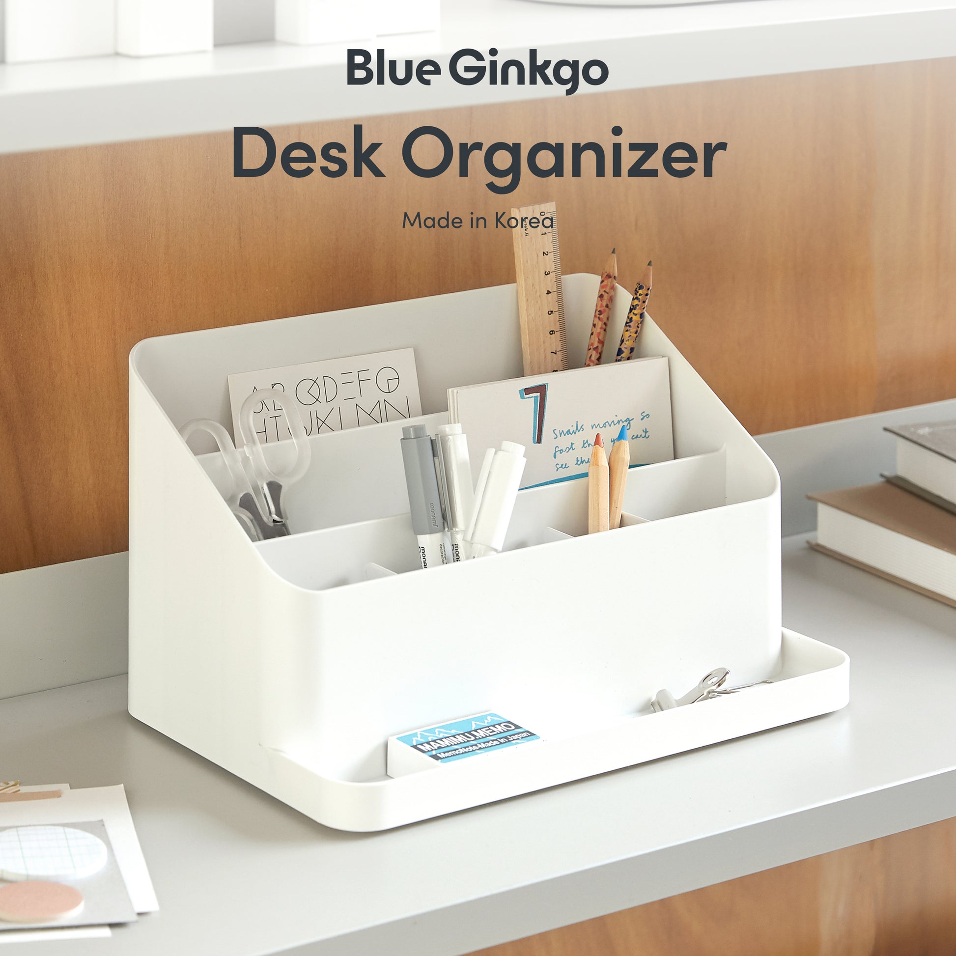 White all-in-one desk organizer with stationery items on a desk.