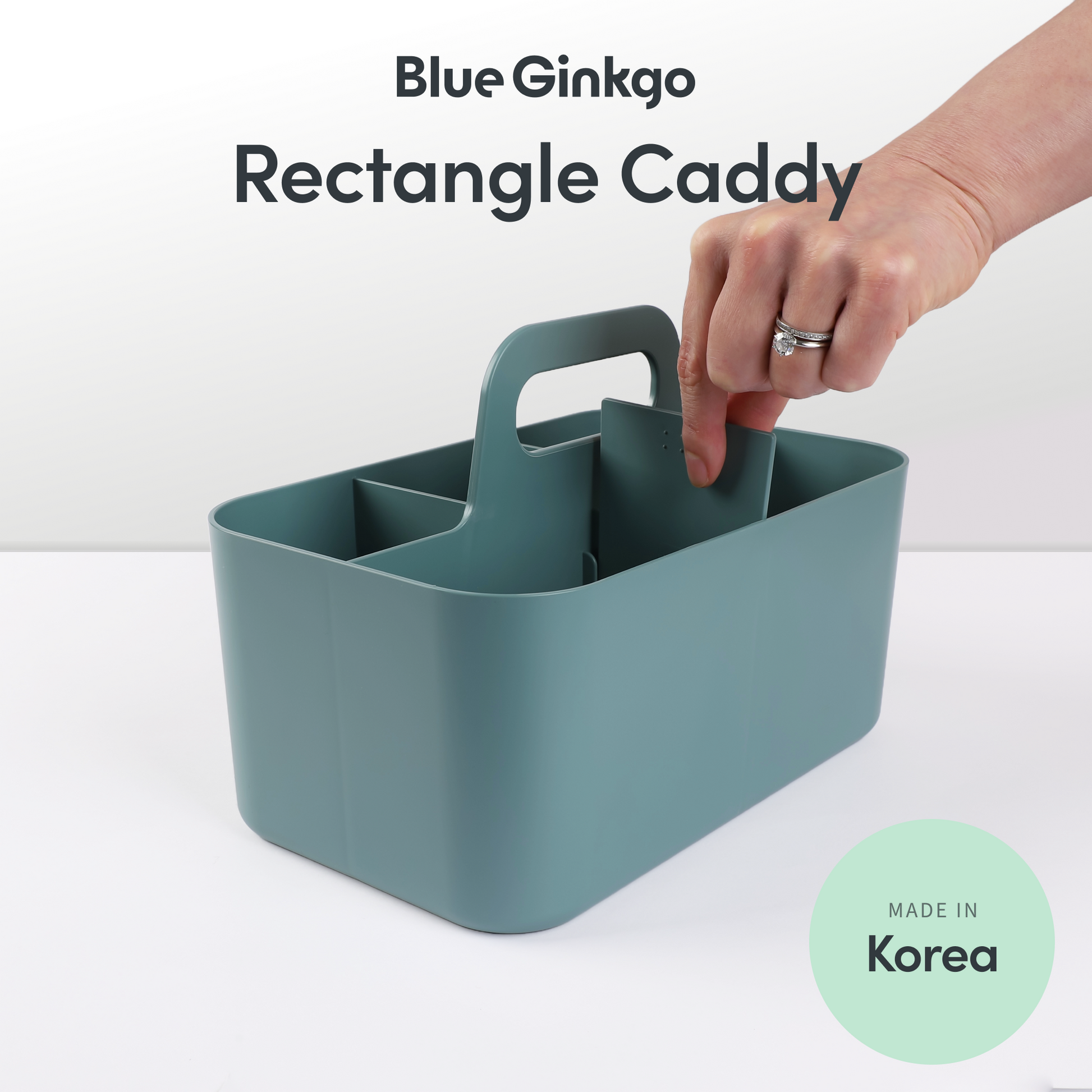 A green rectangle caddy on a white background with a hand removing the removable divider.