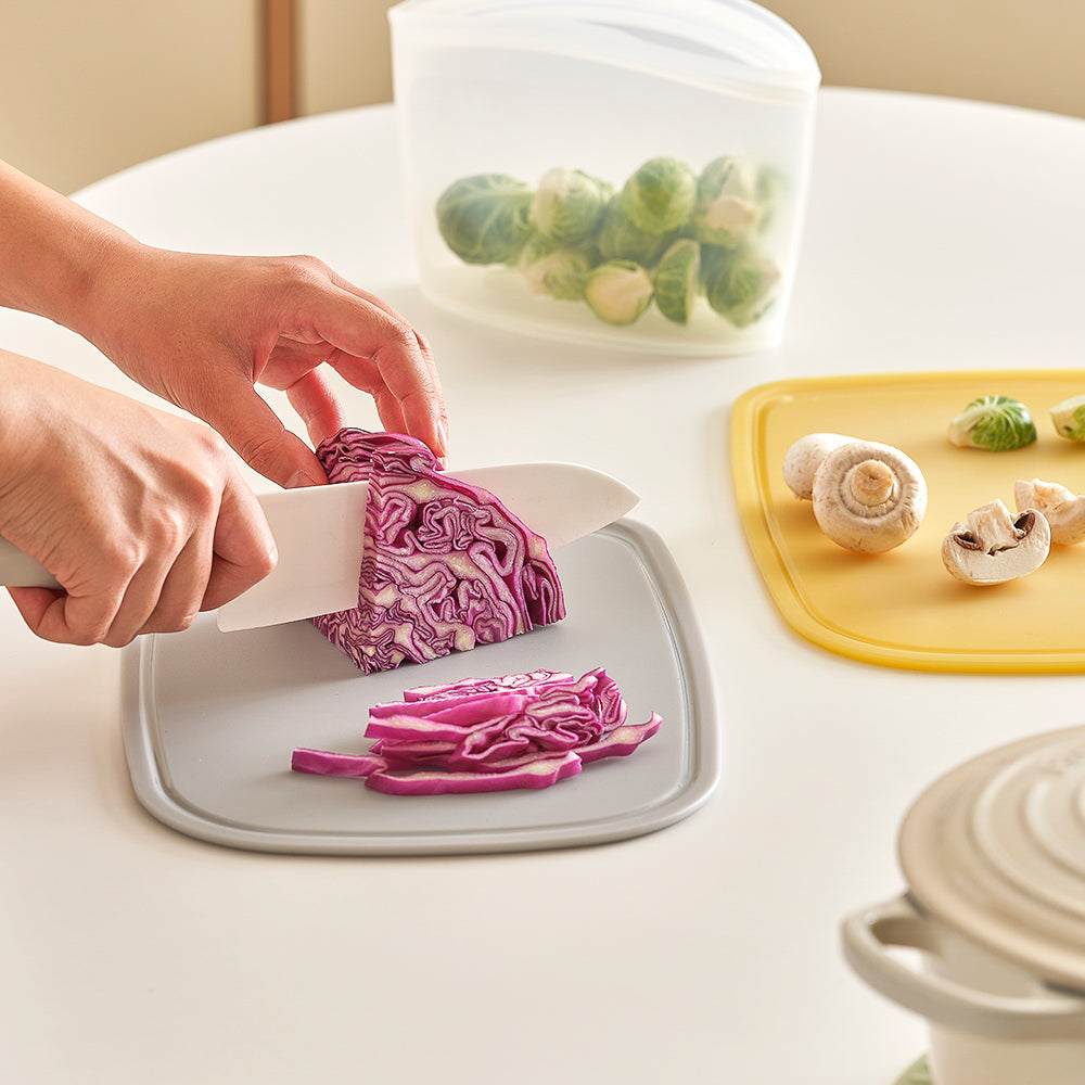 Grey Silicone Cutting Board on white table used to cut red cabbage 