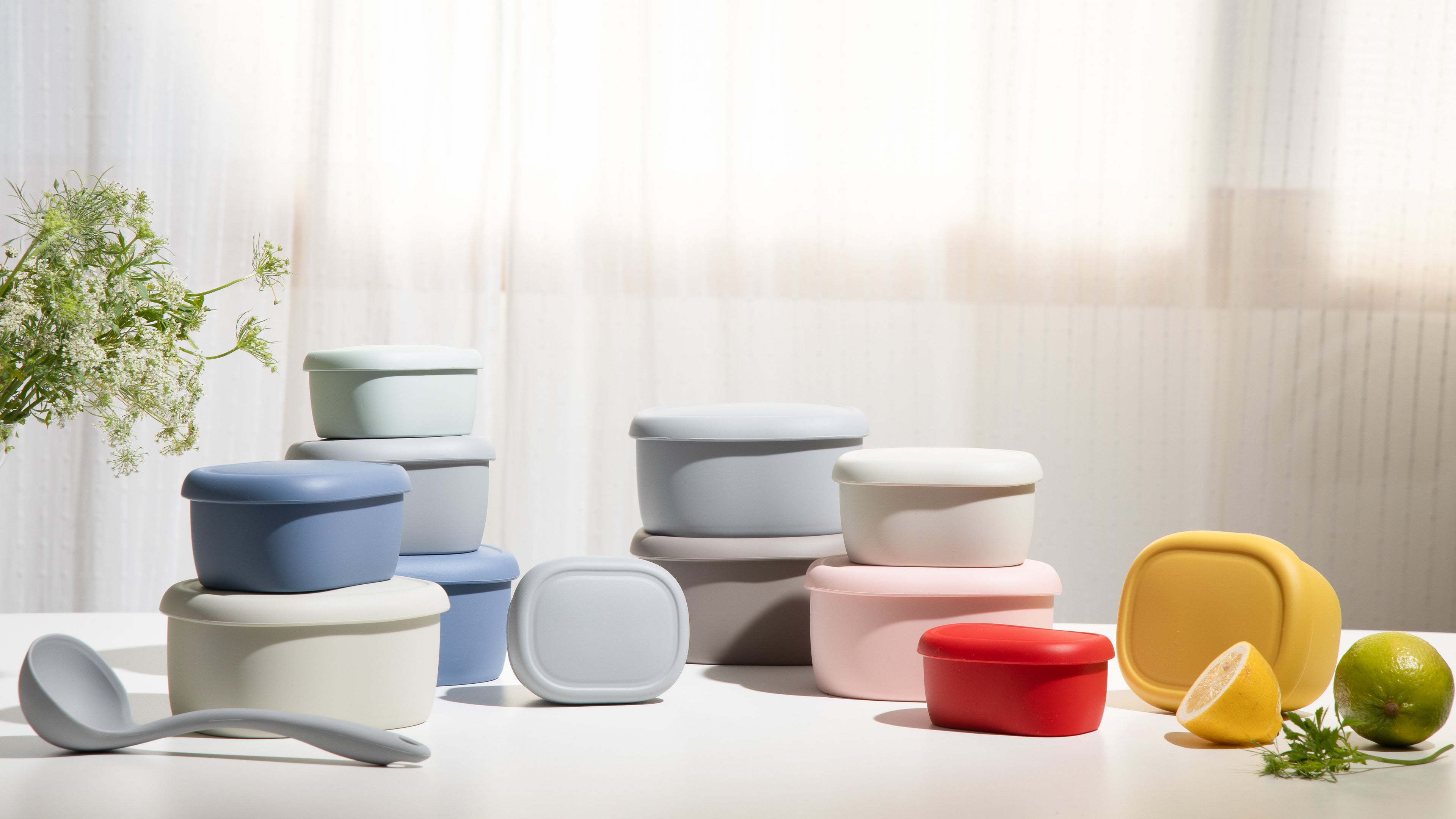 Colorful silicone food containers stacked and displayed on a white kitchen countertop